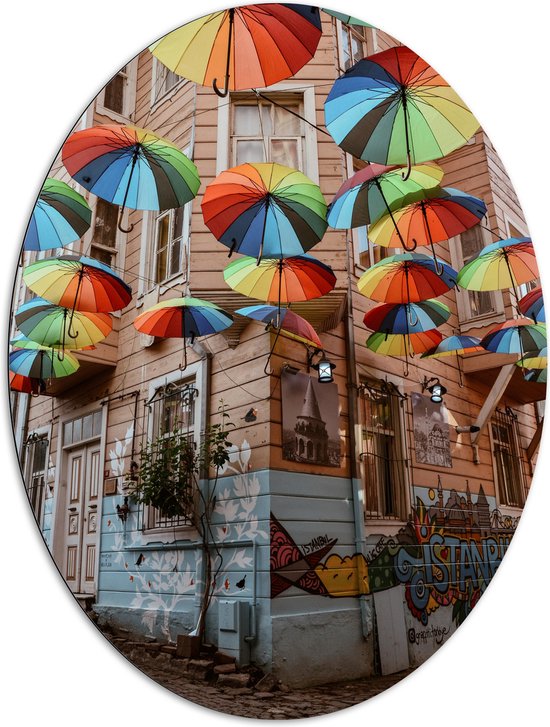 Dibond Ovaal - Plafond van Kleurrijke Paraplu's in Dorpssystraat - 81x108 cm Foto op Ovaal (Met Ophangsysteem)