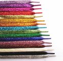 Stapel platte glitterveters in regenboogkleuren, van paars tot zwart.