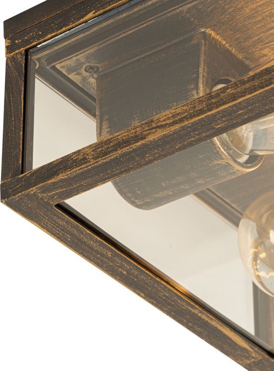 Detail van een vierkante buitenlamp met glazen zijkanten en een verweerd gouden frame.