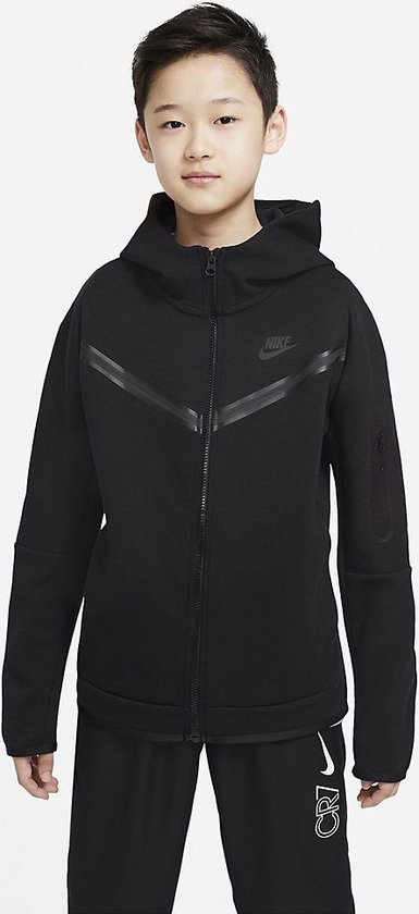 Jongen met een zwart Nike Tech Fleece vest met capuchon, de Nike logo is zichtbaar.