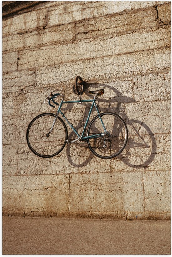 Poster Glanzend – Blauwe Wielrenfiets Hangend aan Stenen Muur - 50x75 cm Foto op Posterpapier met Glanzende Afwerking