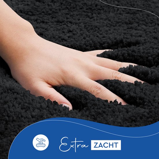 Een hand streelt de zachte, zwarte pluche textuur van de toiletmat. Tekst: 'Extra ZACHT'.