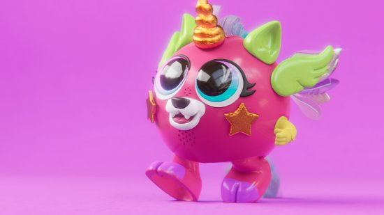 Roze speelgoedfiguur met grote ogen, gouden hoorn, paarse poten en lichtgroene vleugels.
