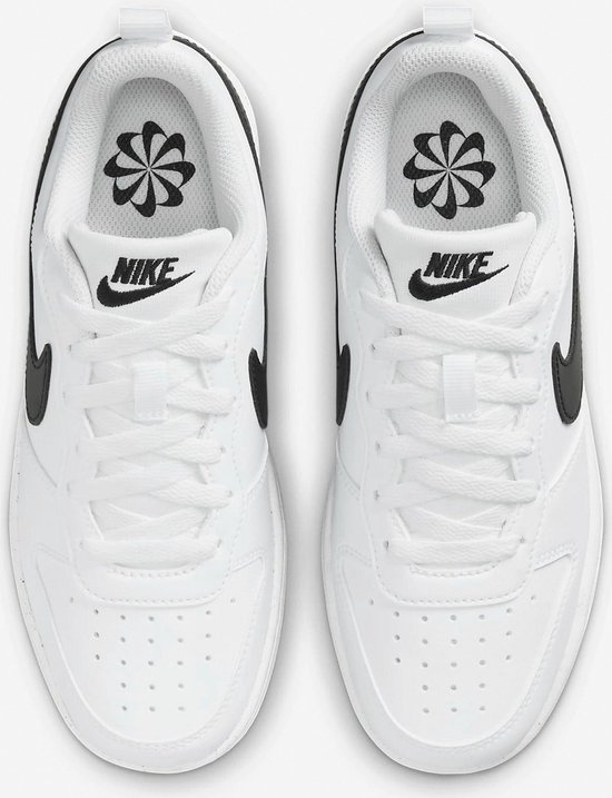 Witte Nike sneakers met zwarte Swoosh en opdruk op de binnenzool.