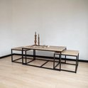 Ensemble de 3 tables basses avec plateaux en bois et cadres en métal noir, deux petites en dessous.