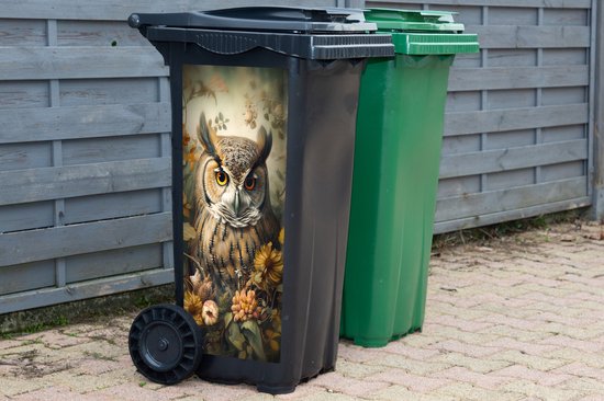 Poubelle noire avec autocollant de hibou, à côté d'une poubelle verte.