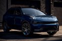 Donkerblauwe Lynk & Co 01 SUV geparkeerd voor een bakstenen muur.