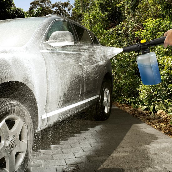 Man wast grijze auto met schuimspuit, met blauwe vloeistof in reservoir.
