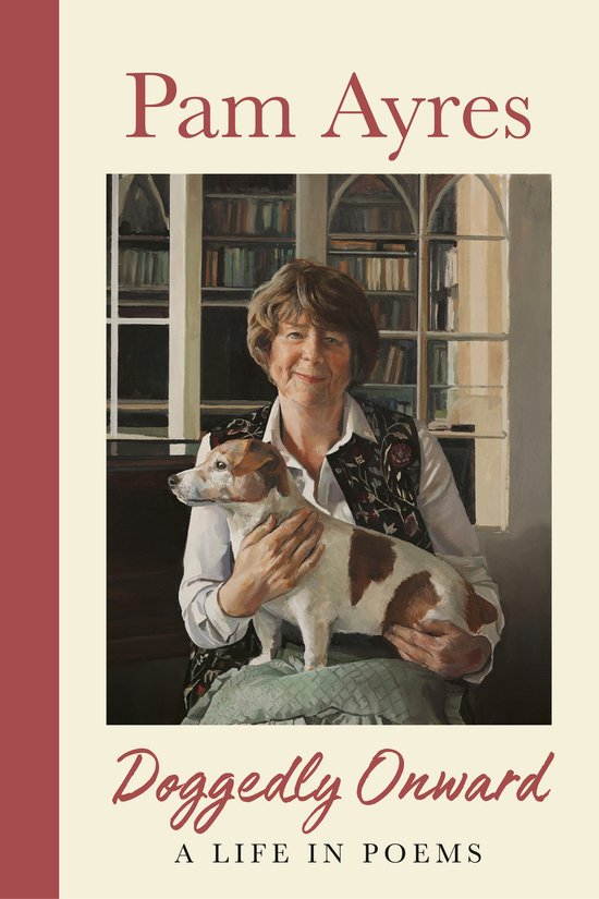 Pam Ayres houdt een Jack Russell terrier vast, zittend in een bibliotheek. Ze draagt een wit overhemd en een geborduurd vest.