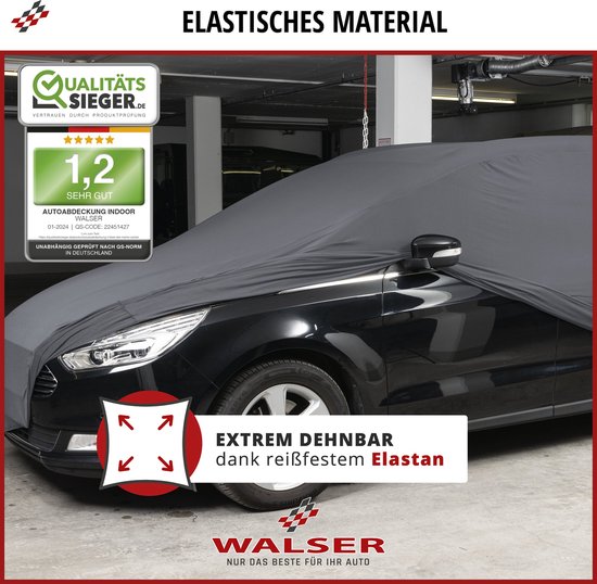 Zwarte auto met grijze, extreem rekbare autohoes van elastisch materiaal, in een garage.