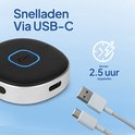 Zwarte, ronde Bluetooth-ontvanger met blauwe LED-ring. USB-C-poort en twee USB-kabels: een USB-A naar USB-C en een USB-C naar USB-C.
