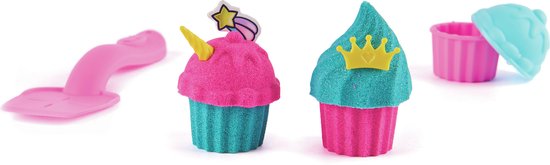 Roze en turquoise kinetische zand cupcakes met eenhoorn- en kroondecoraties, en een roze spatel.