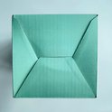 Vue de dessus de l'emballage turquoise fermé de la lampe, avec une fermeture pliée.