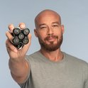 Man met stoppels en baard houdt een zwart Remington scheerapparaat met 5 scheerkoppen voor de camera.