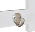 Detail van een metalen haak aan een witte kapstok.