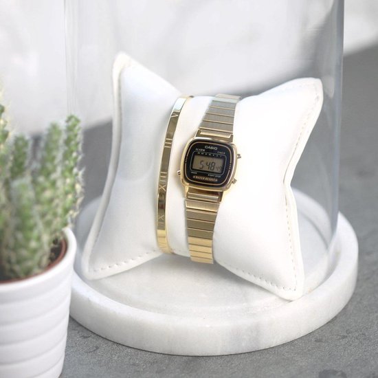 Goudkleurig Casio dameshorloge met digitaal display, naast een armband.