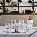 Quatre verres, deux hauts et deux bas, sur une table dressée.