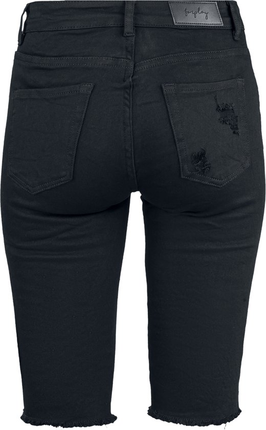 Achterkant van een vrouw in zwarte denim bermudashorts met rafelige zoom.