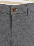 Grijze broek met een subtiel visgraatpatroon en een bruine knoop bij de sluiting.