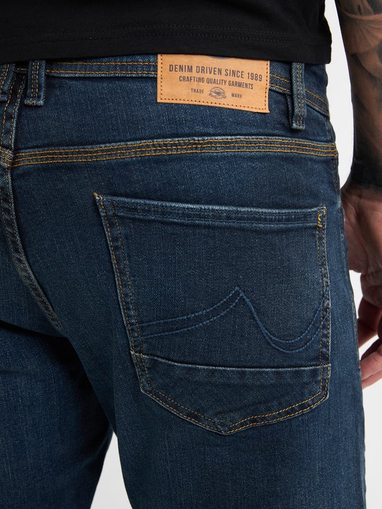 Gros-up van de achterzakken van een donkerblauwe jeans met 'Petrol Industries' label.