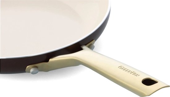 Close-up van een bruine koekenpan met crème binnenkant en een gouden 'GreenPan' handvat.
