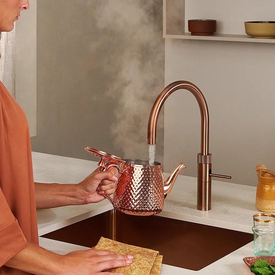 Koperen kraan met Rose Koperen filterketel, water stoomt uit de ketel.