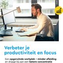 Een lachende man in een wit overhemd werkt aan een computer. Een opgeruimde werkplek verbetert de concentratie.