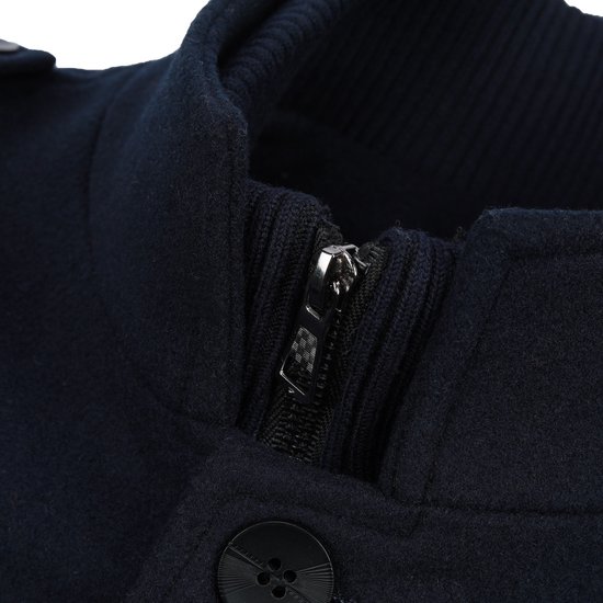 Detail van de ritssluiting en gebreide kraag van een donkerblauwe jas.