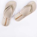 Lichtbeige Ipanema slippers met gouden glitterbandjes, patroon en merklogo.
