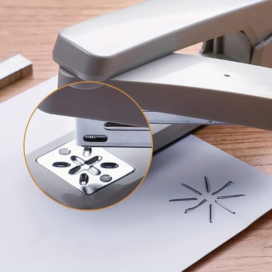 Close-up van een witte nietmachine die papier niet, met een metalen plaat met vierkante perforatie en nietjes in een stervorm.