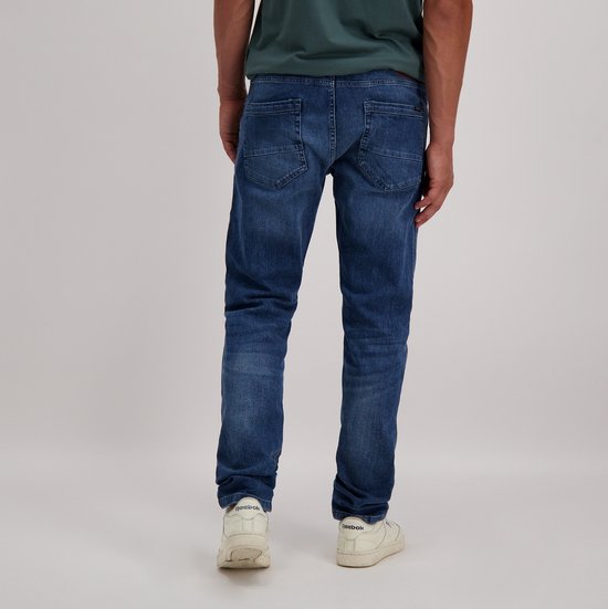 Achterkant van een man die een blauwe denim jeans draagt, met lichte wassing en merklabel.