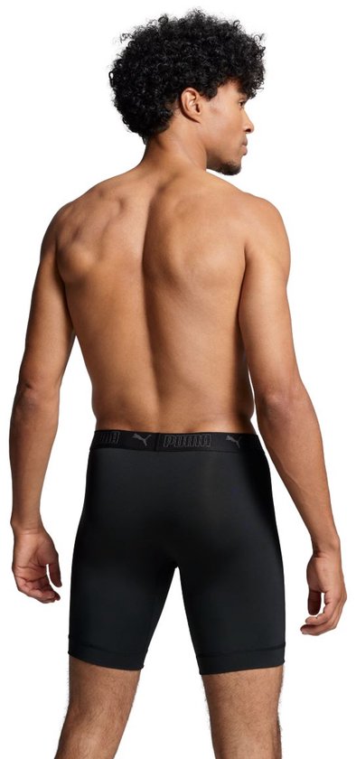 Man, van achteren, draagt zwarte boxer briefs met Puma-logo op de tailleband. Zijn rug en armen zijn zichtbaar.