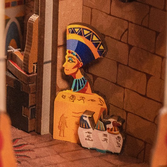 Buste van Nefertiti met blauw-gele hoofdtooi en gedetailleerd Egyptisch beeldhouwwerk op de achtergrond.