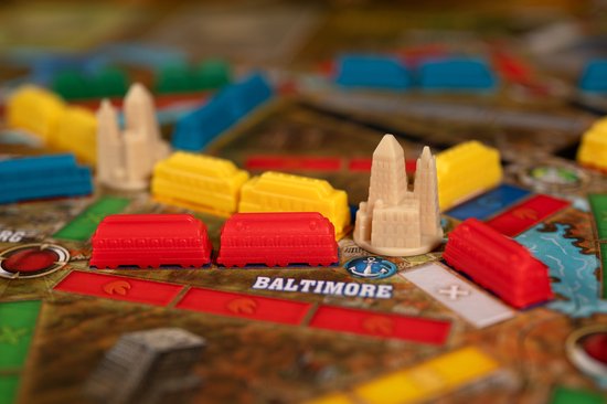 Rode, gele en witte treintjes op een spelbord met de tekst 'Baltimore'.
