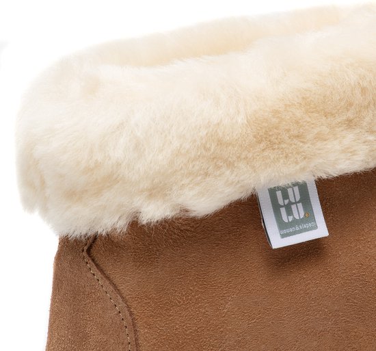 Detail van het LuLu wonen label op een bruine schapenvacht slof met beige bontkraag.