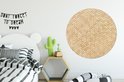 Décoration murale ronde imprimé rotin au-dessus d'un lit avec une literie à rayures noires et blanches.