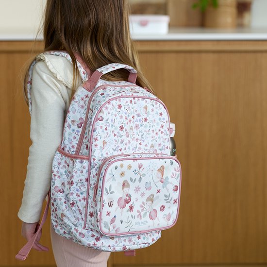 Fille portant un sac à dos avec imprimé floral et de fées, bretelles roses et poche avant.