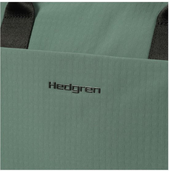 Close-up van het zwarte Hedgren logo op een groene, textuurstof rugzak.