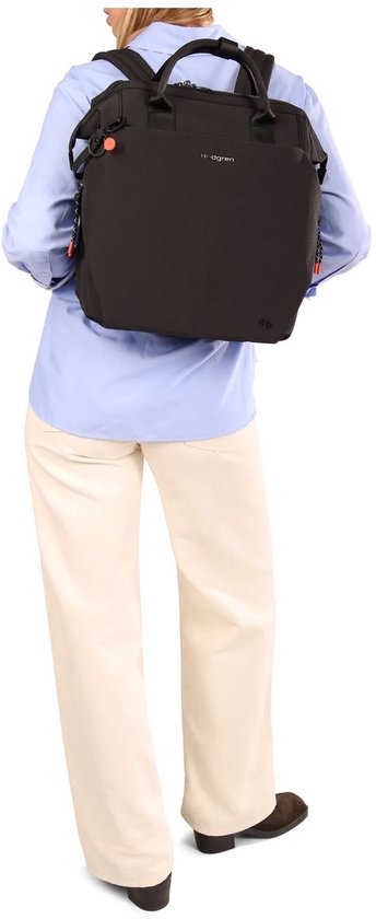 Vrouw met blauw shirt en beige broek, draagt een zwarte Hedgren rugzak.