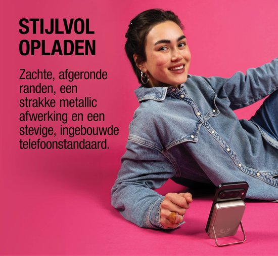Vrouw met spijkerblouse laadt telefoon op met zilverkleurige magnetische powerbank.
