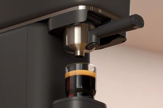 Zwarte Philips Baristina volautomatische espressomachine met een glas espresso.