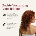 Vrouw met lange, krullende rode haren en een witte handdoek.