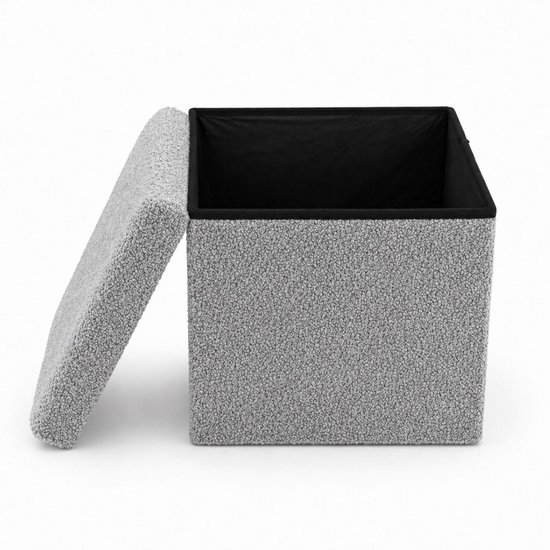 Grijze poef met teddy bouclé stof en zwart interieur. Deksel staat open.