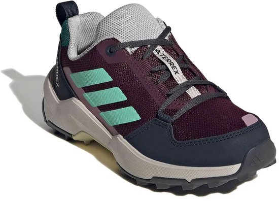 Paarse wandelschoen met mintgroene Adidas stripes, "TERREX" op de veterstrook, lichtroze en donkerblauwe details, en een grijze zool.
