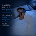 Vrouw slaapt onder een crème deken met quiltpatroon op een bed, met tekst over koel comfort.