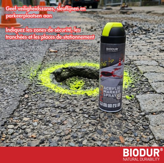 Gele spuitbus met markering op een geasfalteerd terrein, nabij een kuil.