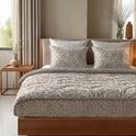 Bed opgemaakt met dekbed en kussenslopen in zandkleurige panterprint.