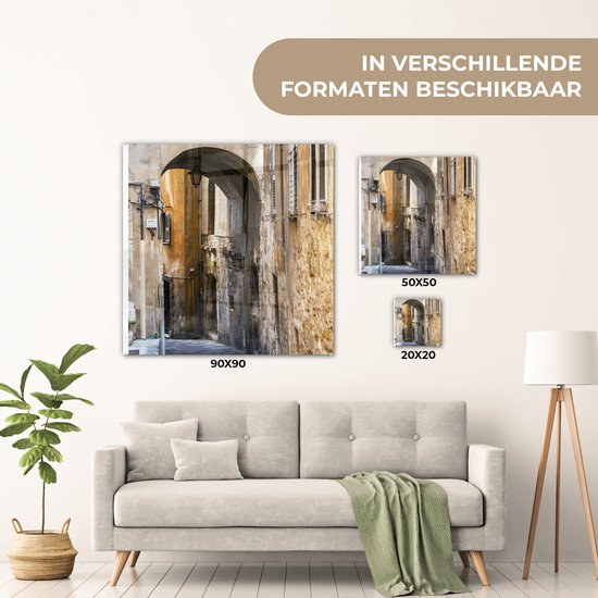 ® Glasschilderij 90x90 cm - Schilderij acrylglas - Stenen boog in een steegje tijdens een zonnige dag - Foto op glas - Muurdecoratie woonkamer - Wanddecoratie slaapkamer - Schilderijen