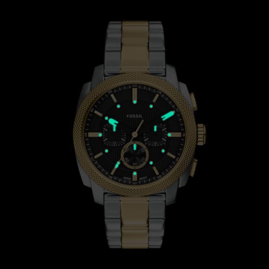Gouden en zilverkleurig Fossil horloge met zwarte wijzerplaat en lichtgevende uurmarkeringen.