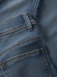 Achterkant van een blauwe skinny spijkerbroek.